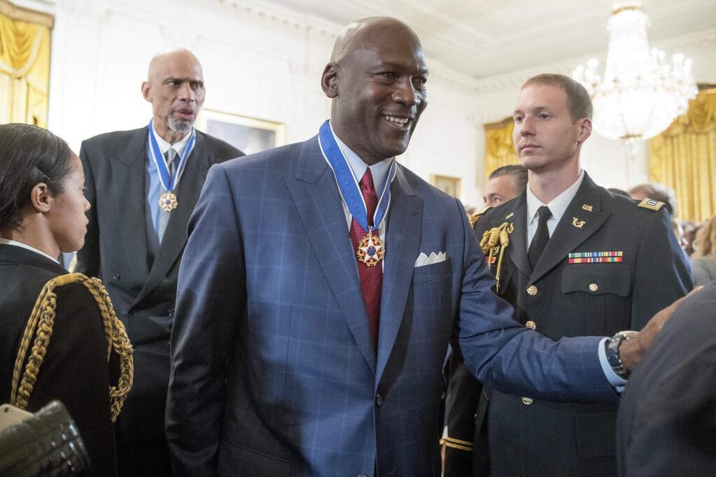 FILE - In this Nov. 22, 2016, file photo, former NBA basketball players Kareem Abdul Jabbar, left, and Michael Jordan, center, depart after receiving the Presidential Medal of Freedom at a ceremony in the East Room of the White House in Washington. Jordan voiced his support for freedom of speech and peaceful protest in a Sept. 24, 2017, statement to the Charlotte Observer following President Donald Trump's decision to rescind a White House invitation to the NBA champion Golden State Warriors. (AP Photo/Andrew Harnik, File)