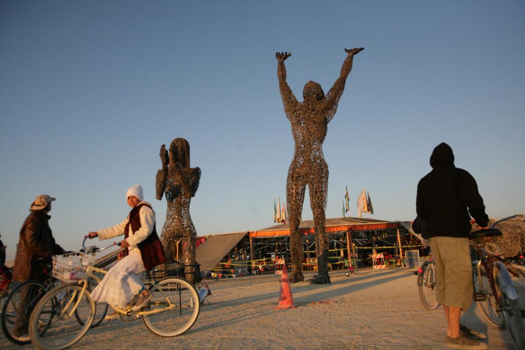 FILE-- An art installation built in front of the center camp at sunrise on the first official day of Burning Man in the Black Rock Desert of Nevada, Aug. 28, 2006. Every year since 1990 building crowds have made the pilgrimage to the Nevada desert to dance, do drugs and make colossal art. (Heidi Schumann/The New York Times)