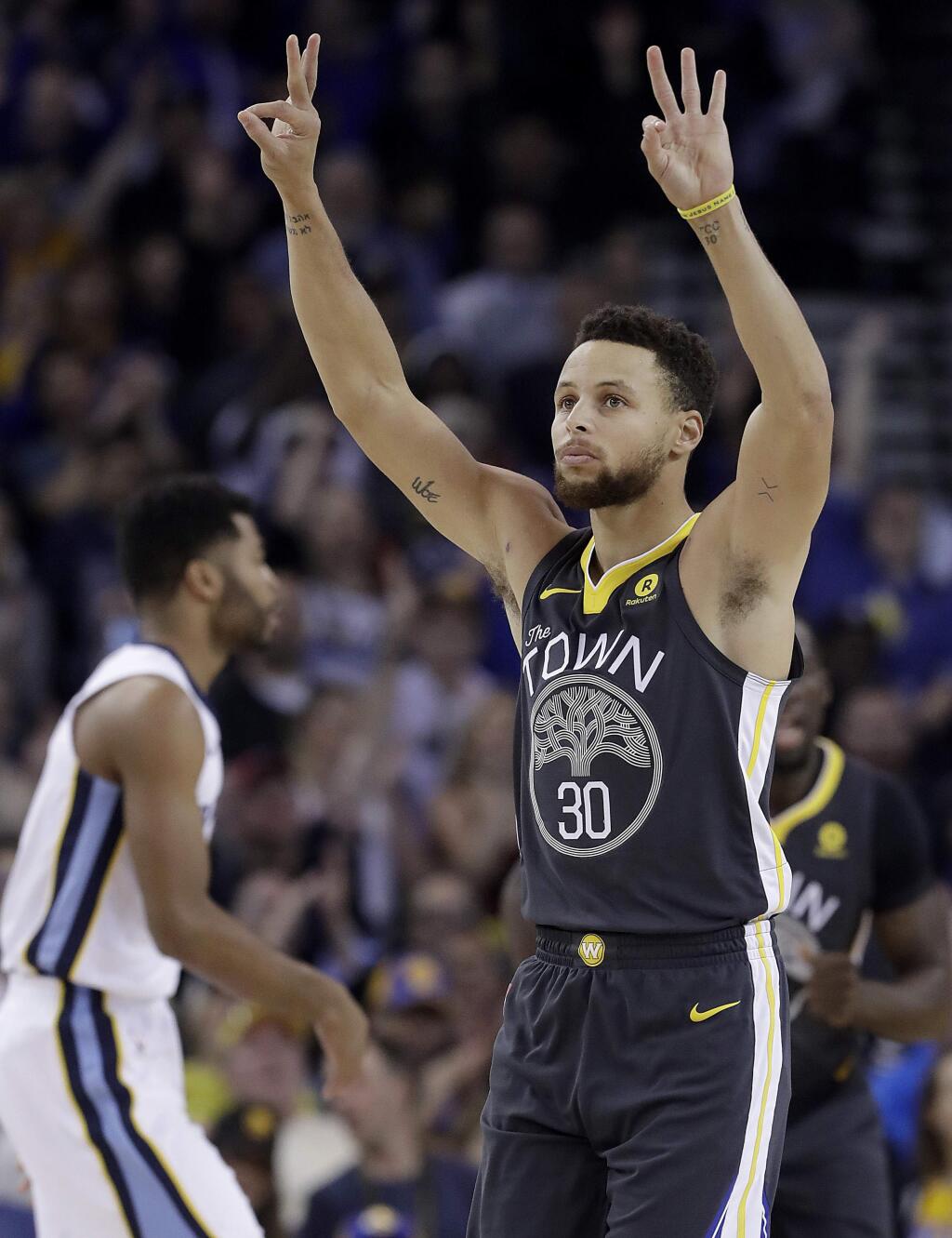 Golden State Warriors guard Stephen Curry (30) gestures after scoring during the first half of the team's NBA basketball game against the Memphis Grizzlies in Oakland, Calif., Saturday, Dec. 30, 2017. (AP Photo/Jeff Chiu)