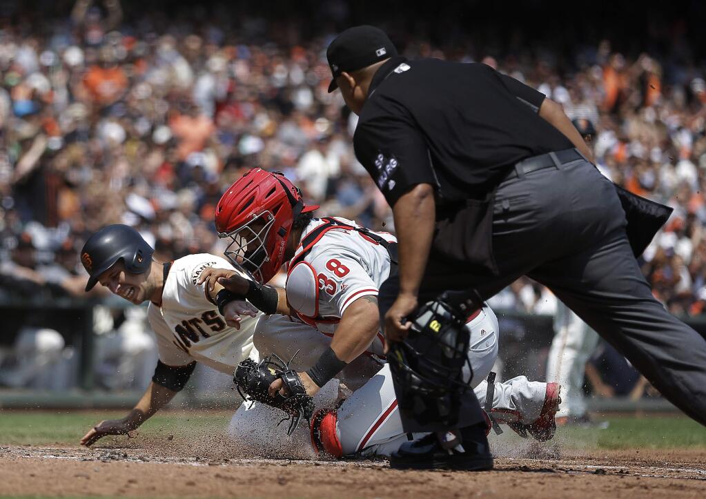 Philadelphia Phillies catcher Jorge Alfaro (38) tags out San Francisco Giants' Buster Posey in the third inning of a baseball game, Sunday, Aug. 20, 2017, in San Francisco. Posey tried to score on a single by Giants' Brandon Crawford. At right is home plate umpire Adrian Johnson. (AP Photo/Ben Margot)