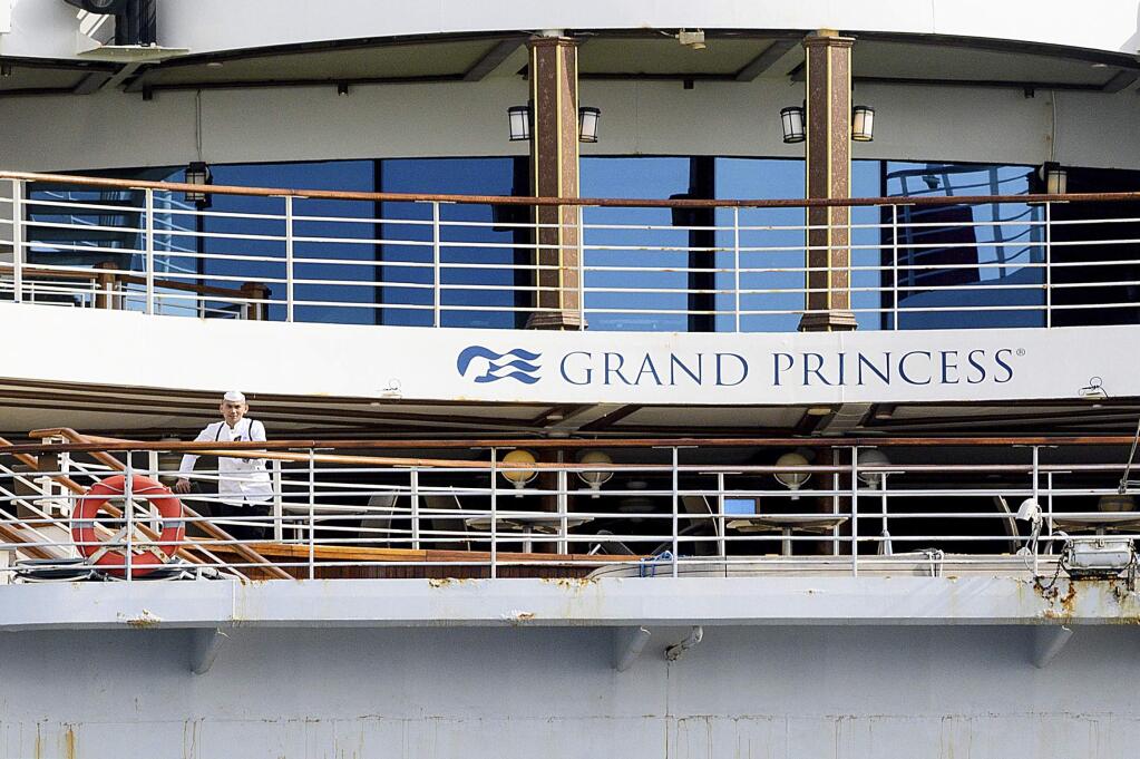 A crewman stands aboard the Grand Princess as it maintains a holding pattern about 25 miles off the coast of San Francisco on Sunday, March 8, 2020. The cruise ship is scheduled to dock at the Port of Oakland on Monday for COVID-19 quarantine after 21 people tested positive for the virus. (AP Photo/Noah Berger)