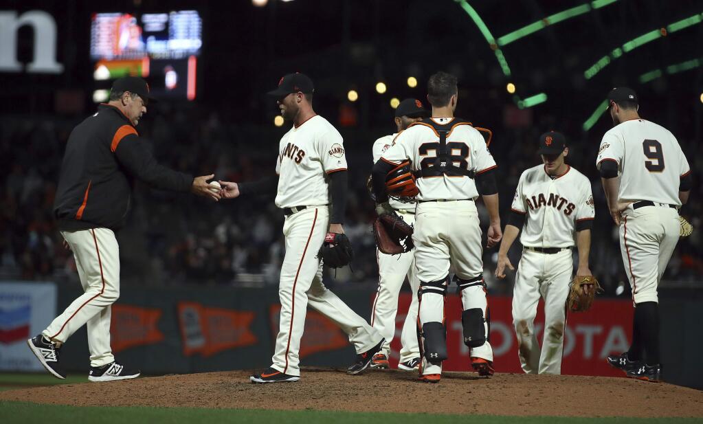 San Francisco Giants manager Bruce Bochy, left, relieves pitcher Hunter Strickland in the ninth inning of a baseball game against the Miami Marlins Monday, June 18, 2018, in San Francisco. (AP Photo/Ben Margot)