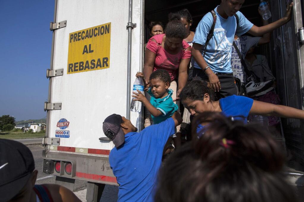 Joel Eduardo Espinar reaches for his son, Eduardo, 2, from his wife, Yamilet, while arriving in Arriaga, Mexico, after a ride on a truck. His plan is to request asylum rather than cross the border illegally. 'I'm kind of fearful of what will happen once we get to the U.S. border,' he said. Regardless, he says, they will not go back to Honduras. (AP Photo/Rodrigo Abd)