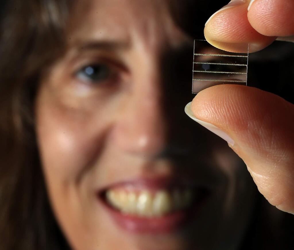 Karen Hendrix, Principal Filter Design Engineer for Viavi Solutions, holds an uncoated example of a 12mm Linear Variable fFilter that will be aboard a U.S. Spacecraft hearing for the asteroid Bennu this month. (JOHN BURGESS/The Press Democrat)