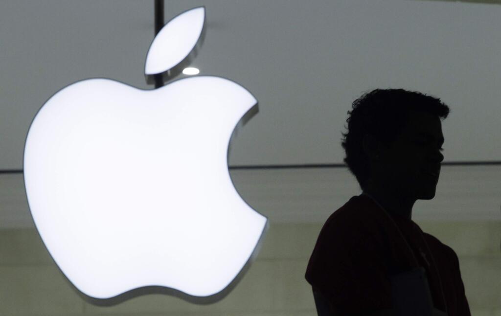 In a Wednesday, Dec. 7, 2011, file photo, a person stands near the Apple logo at the company's store in Grand Central Terminal, in New York. Apple will show off its newest products Sept. 9, 2014. (AP Photo/Mark Lennihan, File)