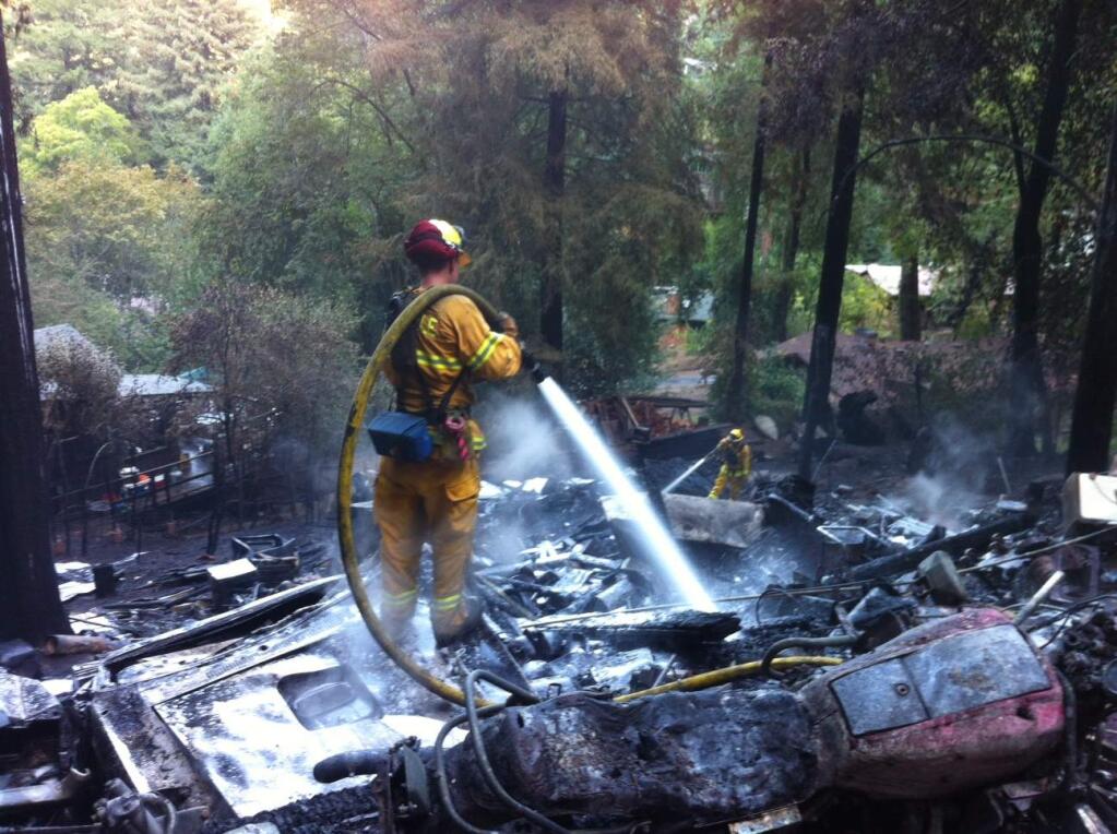Cal Fire firefighters douse hot spots on Hillside Drive in Summerhome Park west of Forestville on Monday, Sept. 1, 2014. (Kent Porter / The Press Democrat)