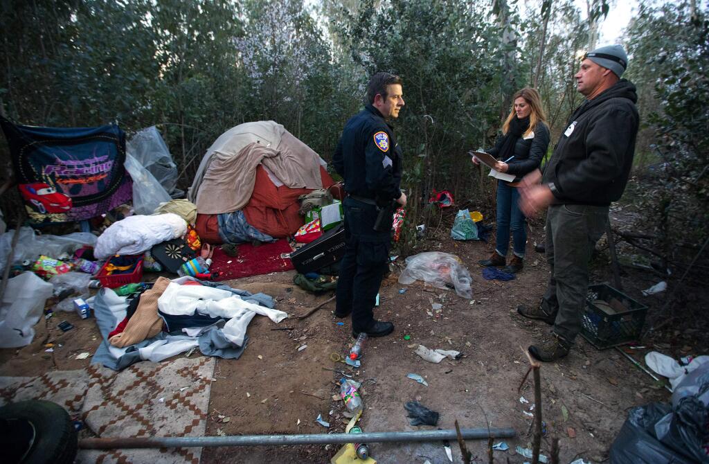 From left, Sgt. Jonathan Wolf, Lisa Boehm and Keith Flood record the age and gender of homeless people living in an encampment off Piner Rd. on Friday during the annual census of the homeless in Sonoma County. (photo by John Burgess/The Press Democrat)