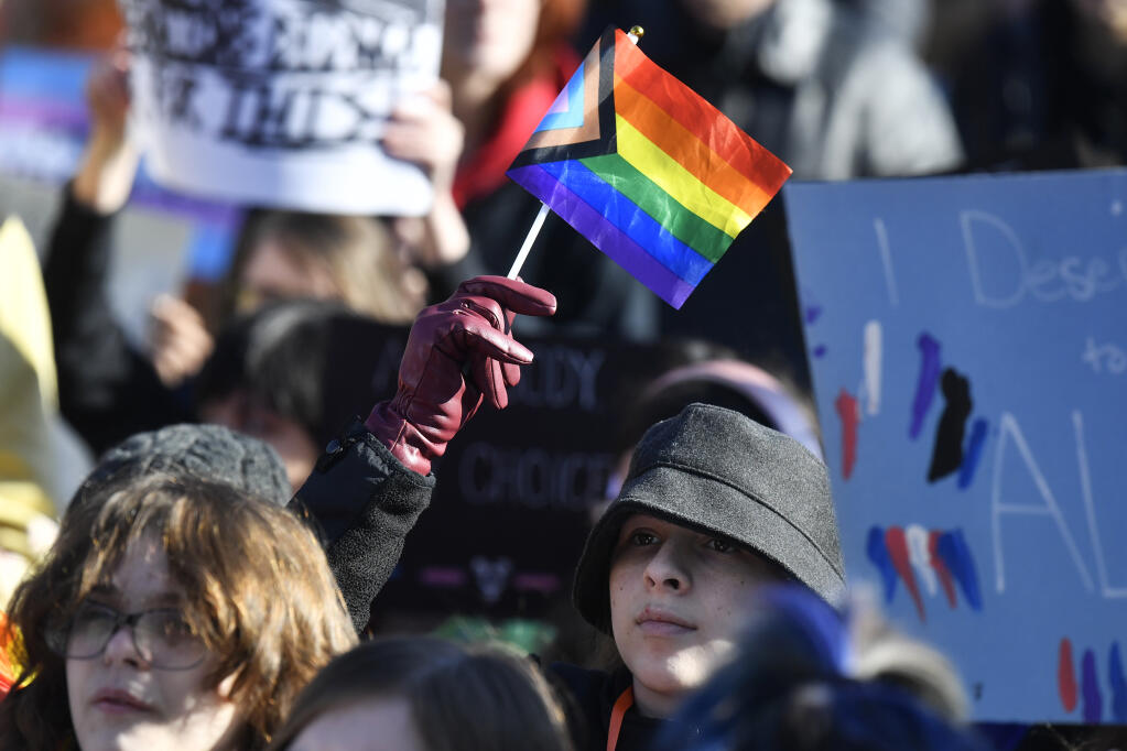 A protester waves a rainbow flag during a rally against the Transgender Health Bill on the lawn of the Kentucky State Capitol in Frankfort, Ky., Wednesday, March 29, 2023. (AP Photo/Timothy D. Easley)