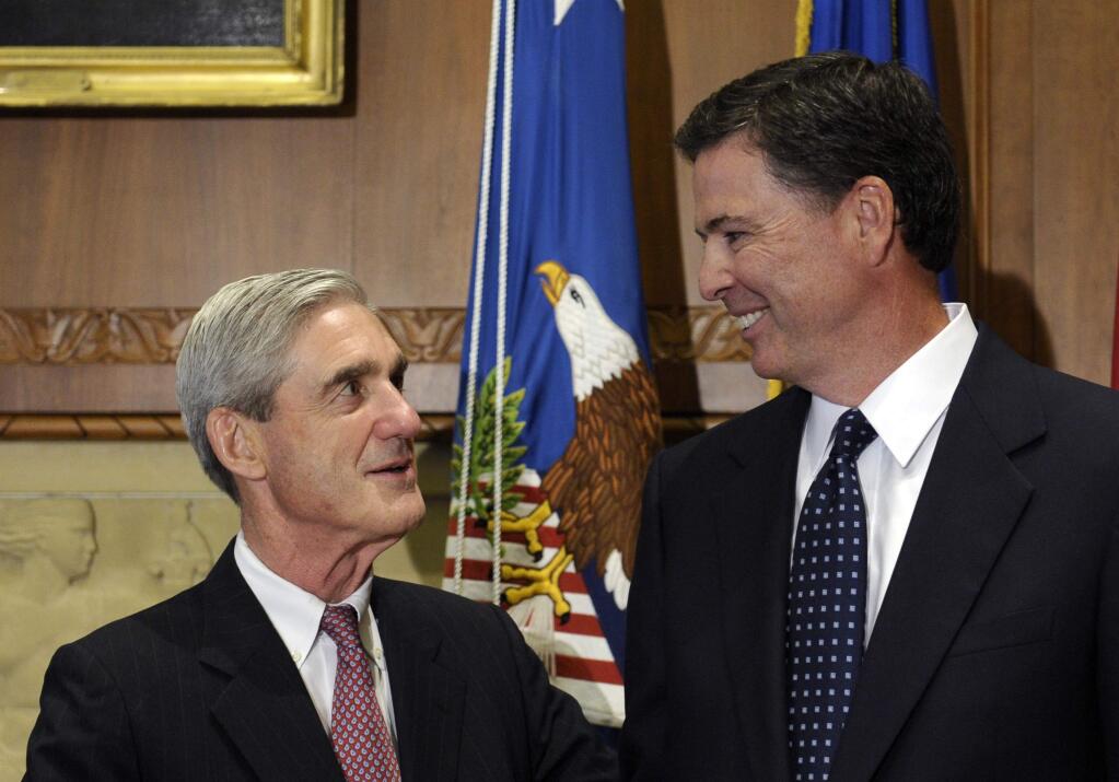 FILE - In this Sept. 4, 2013, file photo, then-incoming FBI Director James Comey talks with outgoing FBI Director Robert Mueller before Comey was officially sworn in at the Justice Department in Washington. On May 17, 2017, the Justice Department said is appointing Mueller as special counsel to oversee investigation into Russian interference in the 2016 presidential election. (AP Photo/Susan Walsh, File)