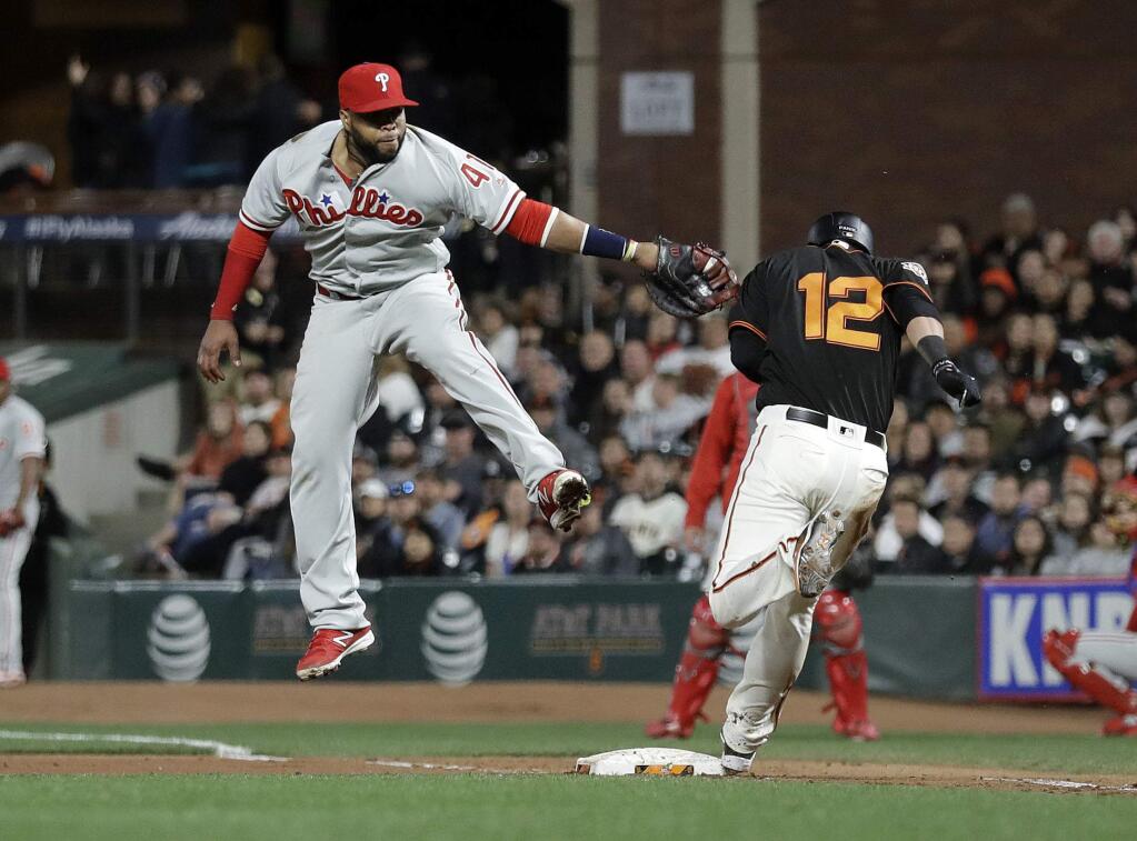 The San Francisco Giants' Joe Panik is safe at first base for an infield single past the tag attempt from Philadelphia Phillies first baseman Carlos Santana during the eighth inning Saturday, June 2, 2018, in San Francisco. (AP Photo/Marcio Jose Sanchez)