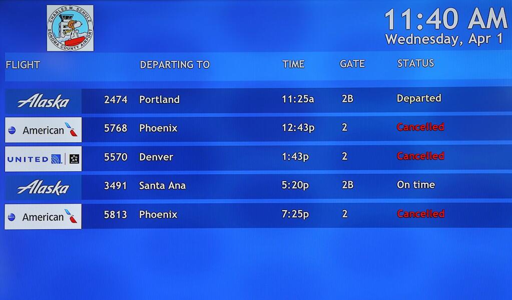 A monitor lists several cancelled departures at the Charles M. Schulz-Sonoma County Airport in Santa Rosa on Wednesday, April 1, 2020. (Christopher Chung/ The Press Democrat)