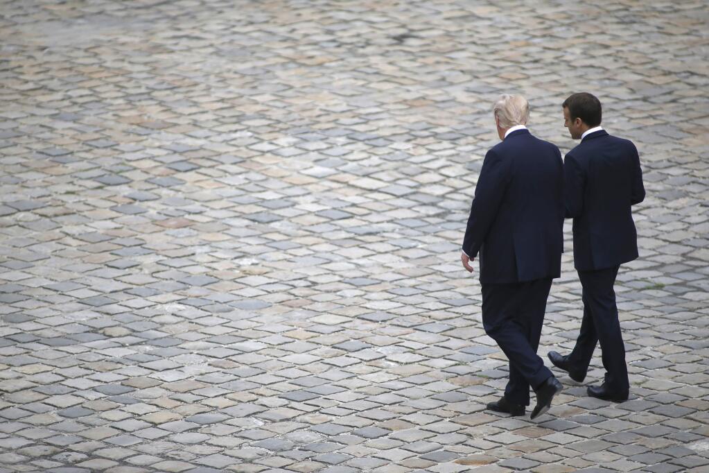 French President Emmanuel Macron and US President Donald Trump walk in the courtyard of the Invalides in Paris, after an official welcoming ceremony, Thursday, July 13, 2017. Trump is in Paris for a high profile two-day visit during which he will be the guest of honour of his French counterpart Emmanuel Macron at the annual Bastille Day parade. (AP Photo / Matthieu Alexandre)