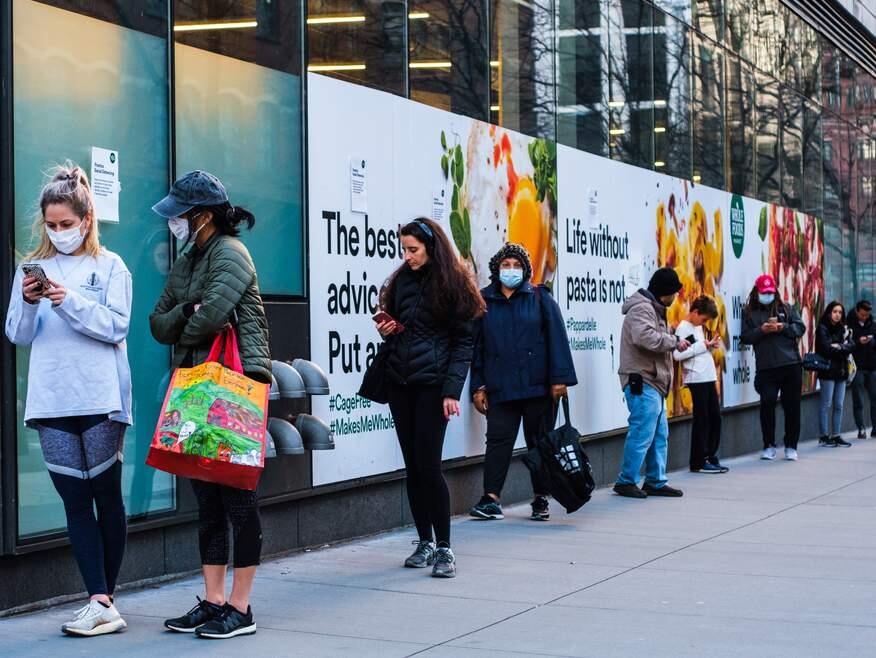 A long line outside of Whole Foods in Tribeca, New York as the store has implemented social distancing measures during the COVID-19 pandemic. (Jennifer M. Mason/Shutterstock)