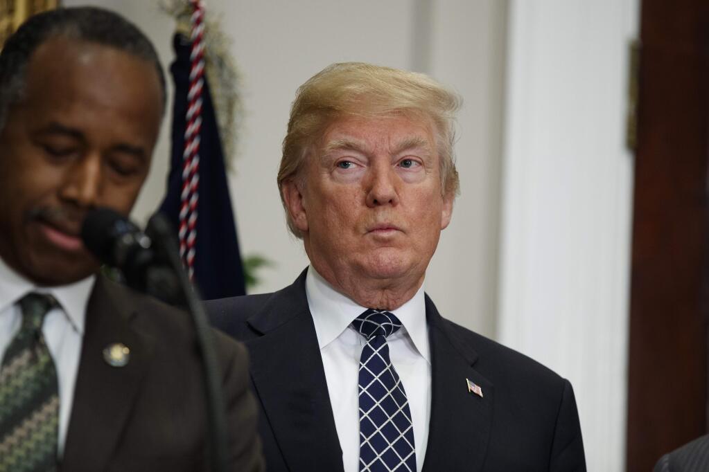 President Donald Trump listens as Secretary of Housing and Urban Development Ben Carson speaks during an event to honor Dr. Martin Luther King Jr., in the Roosevelt Room of the White House, Friday, Jan. 12, 2018, in Washington. (AP Photo/Evan Vucci)
