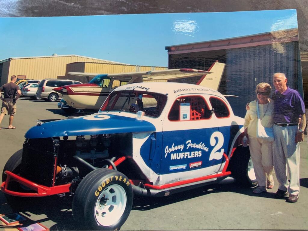 Mildred and Frank Johnson at the Sonoma County Airport alongside a replica of the Ford Hardtop he'd raced decades earlier. Behind is the airplane Frank Johnson flew as KSRO's 'Weather Bird.' (Johnson family)