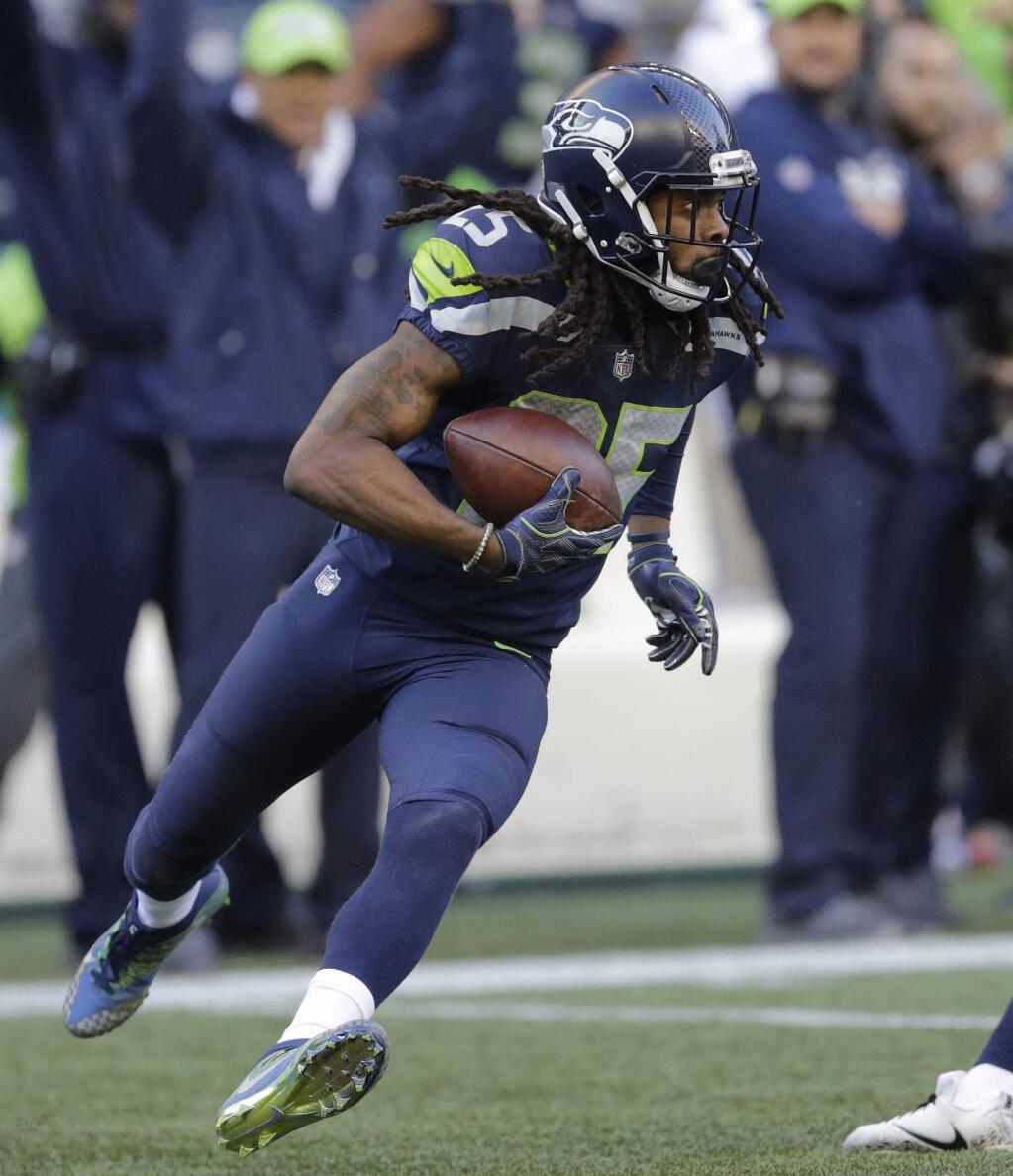 In this Oct. 29, 2017, file photo, Seattle Seahawks cornerback Richard Sherman runs after he intercepted a pass from Houston Texans quarterback Deshaun Watson late in the second half in Seattle. (AP Photo/Stephen Brashear, File)
