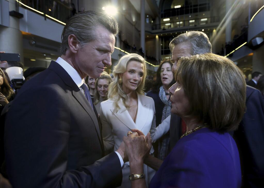 FILE - In this Jan. 7, 2019, file photo, California Gov. Gavin Newsom, left, talks with U.S. House Speaker Nancy Pelosi in Sacramento, Newsom has hung his hopes for avoiding drastic California budget cuts squarely on the federal government. His budget proposal Thursday, May 14, 2020 warned of $14 billion in cuts to public education and other areas if Congress doesn't approve more coronavirus-related funding. (AP Photo/Rich Pedroncelli, File)