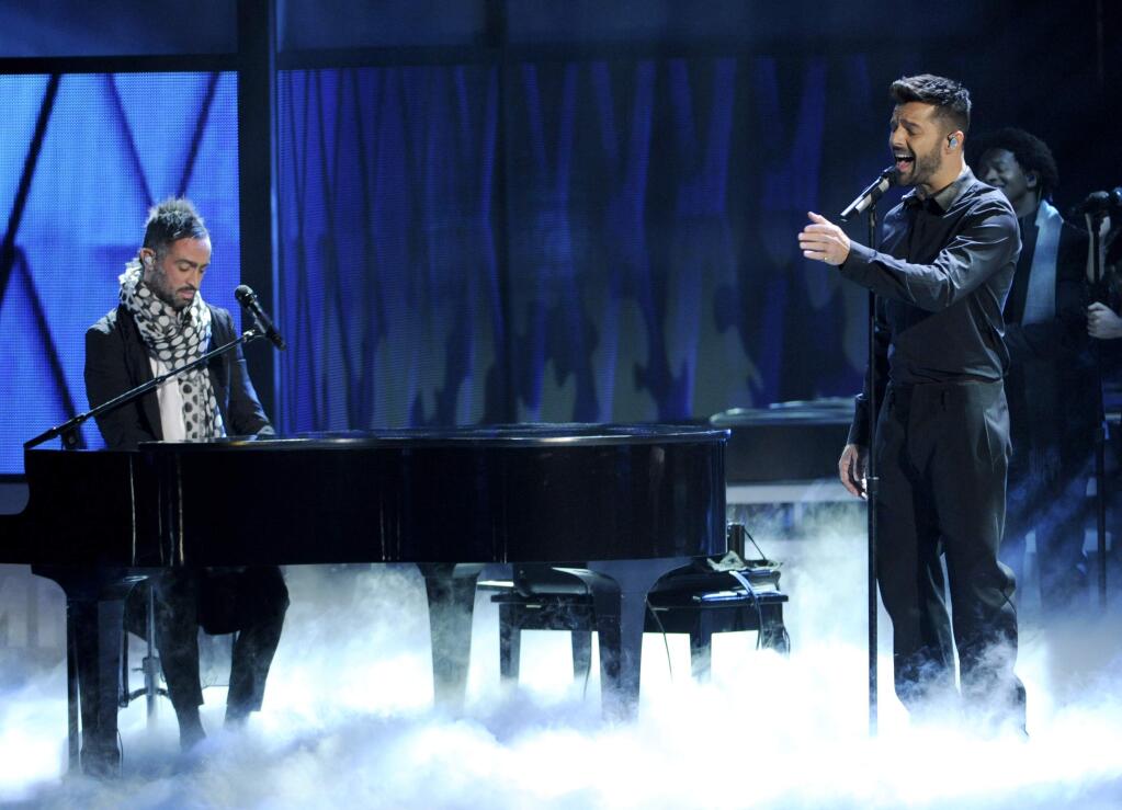 Mario Domm, of the musical group Camila, left, and Ricky Martin perform on stage at the 15th annual Latin Grammy Awards at the MGM Grand Garden Arena on Thursday, Nov. 20, 2014, in Las Vegas. (Photo by Chris Pizzello/Invision/AP)