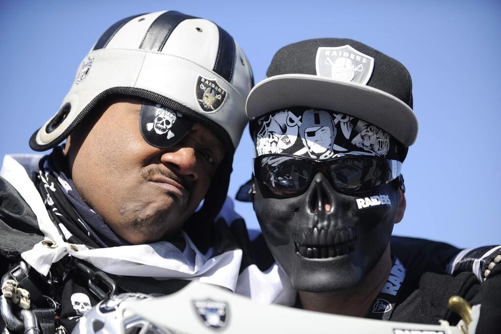 Oakland Raiders fans pose for a photo before the first half of an AFC wild-card game between the Houston Texans and the Oakland Raiders, Saturday, Jan. 7, 2017, in Houston. (AP Photo/Eric Christian Smith)