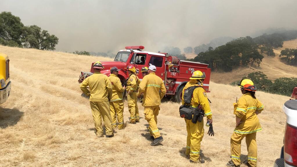 Firefighters gather near the town of Hopland on Old River Road south of Talmage. The 5-acre River fire closed Old River Road from the 6800 block to the 10500 block on Friday, July 27, 2018. (Kent Porter/Press Democrat)(Kent Porter/Press Democrat)