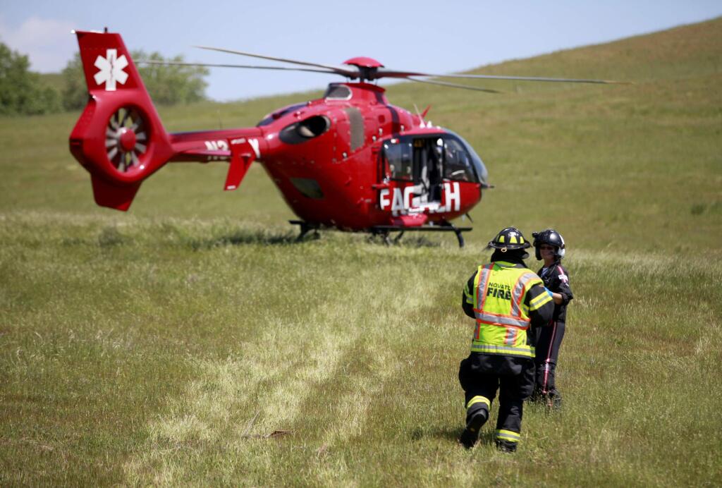 A REACH air ambulance prepares to transport an injured child to Oakland Children's Hospital at the scene of a 3 vehicle accident on Lakeville Hwy, about 1 mile north of Hwy 37, on Monday, April 28, 2014 in Petaluma, California. (BETH SCHLANKER/ The Press Democrat)