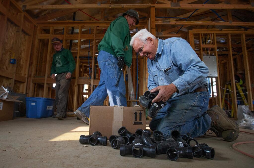 Dick Crawford of Livermore looks for the correct pipe fitting in a home destroyed by the Valley Fire in Middletown. Volunteers with the Hope Crisis Response Network are rebuilding homes destroyed in the Valley Fire and will continue their efforts in Santa Rosa after the Tubbs Fire. (photo by John Burgess/The Press Democrat)