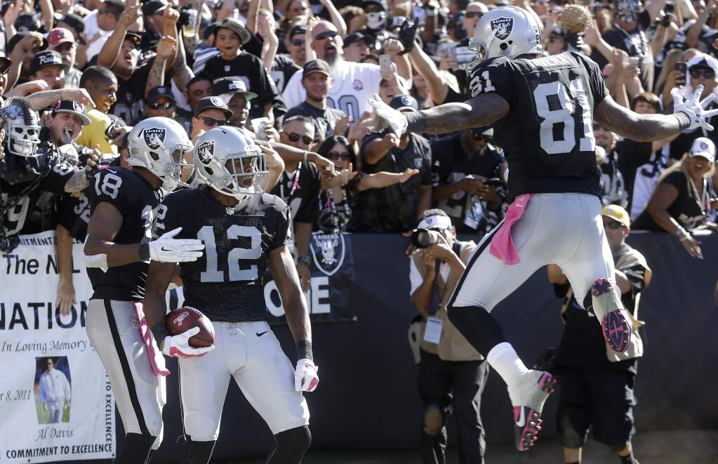 Oakland Raiders wide receiver Brice Butler (12) celebrates after scoring on a 47-yard touchdown reception with wide receiver Andre Holmes (18) and tight end Mychal Rivera (81) during the third quarter of an NFL football game against the San Diego Chargers in Oakland Sunday, Oct. 12, 2014. (AP Photo/Ben Margot)