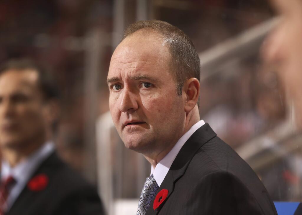 FILE - In this Nov. 7, 2014, file photo, then-New Jersey Devils head coach Peter DeBoer watches the second period of an NHL hockey game against the Detroit Red Wings in Detroit. The San Jose Sharks will hire Peter DeBoer as their new head coach. A person familiar with the search said Wednesday, May 27, 2015, that DeBoer will be formally introduced later this week. The person spoke on condition of anonymity because the team had not announced the hire yet. ESPN first reported the move. (AP Photo/Paul Sancya, File)