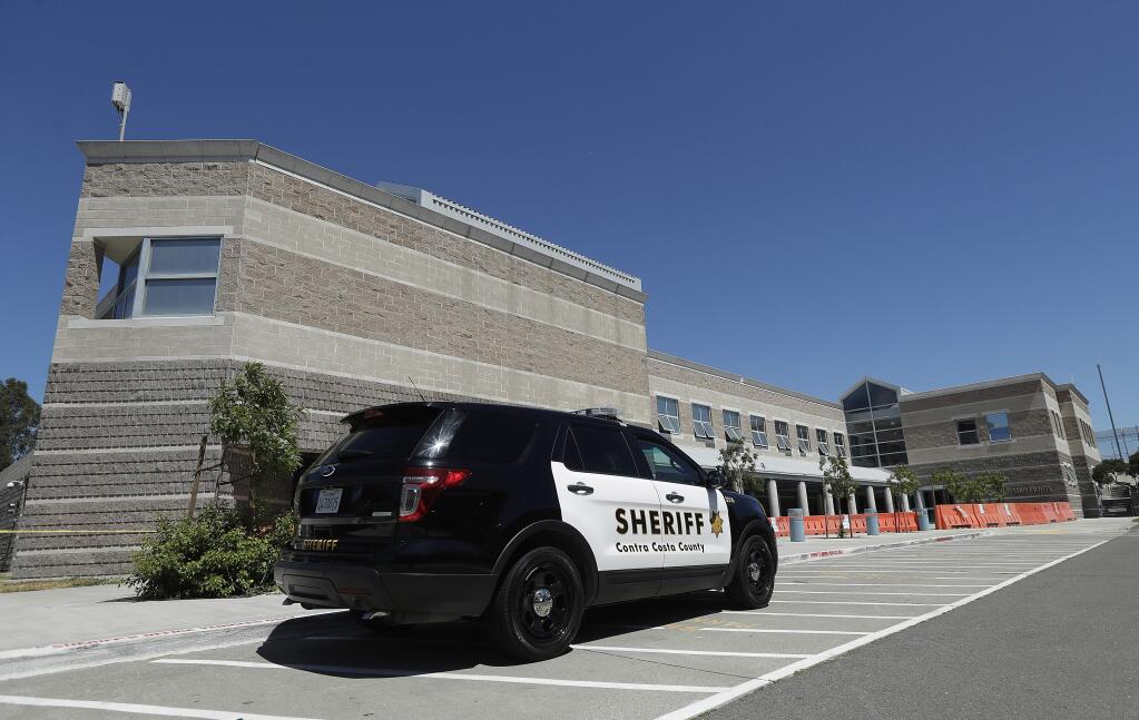 A Contra Costa County Sheriff's vehicle is parked in front of the West County Detention Center in Richmond, Calif., Tuesday, July 10, 2018. Authorities say the Northern California jail will cancel its profitable contract with federal immigration officials to house suspects facing deportation. The Contra Costa County Sheriff's Department on Tuesday became the third local law enforcement agency in California to cut ties in recent months with U.S. Immigration and Customs Enforcement officials amid continued protests over federal detention policies. (AP Photo/Jeff Chiu)