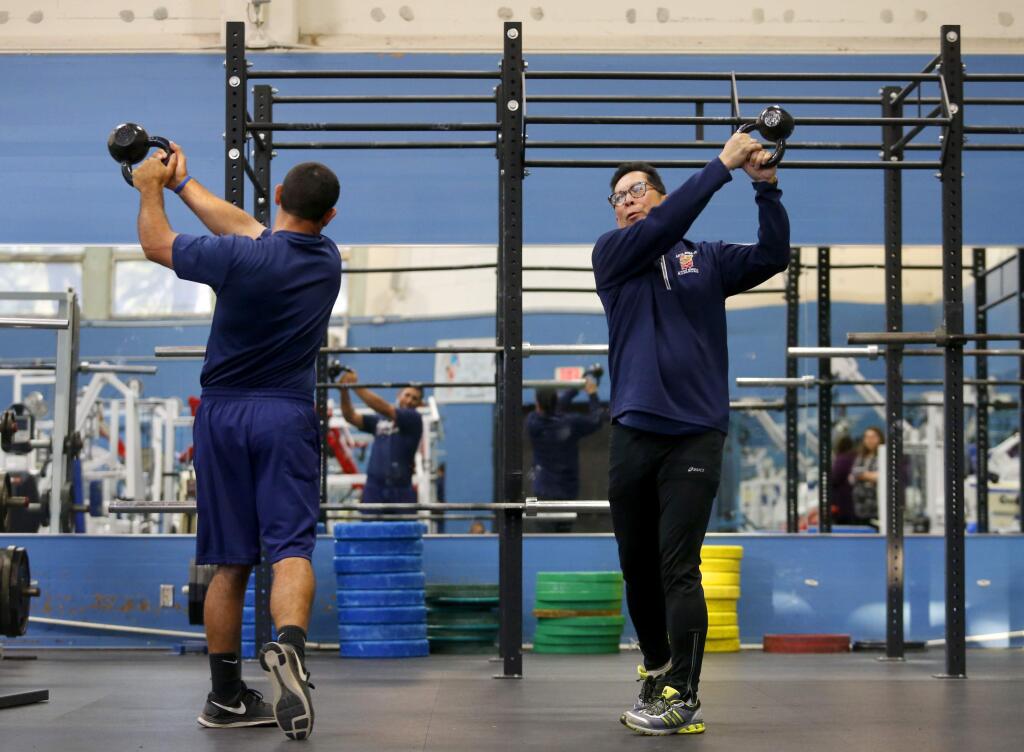 Santa Rosa Junior College president Frank Chong works out with assistant baseball coach Ben Buechner at Tauzer Gymnasium on the SRJC campus in Santa Rosa, on Tuesday, April 5, 2016. (BETH SCHLANKER/ The Press Democrat)