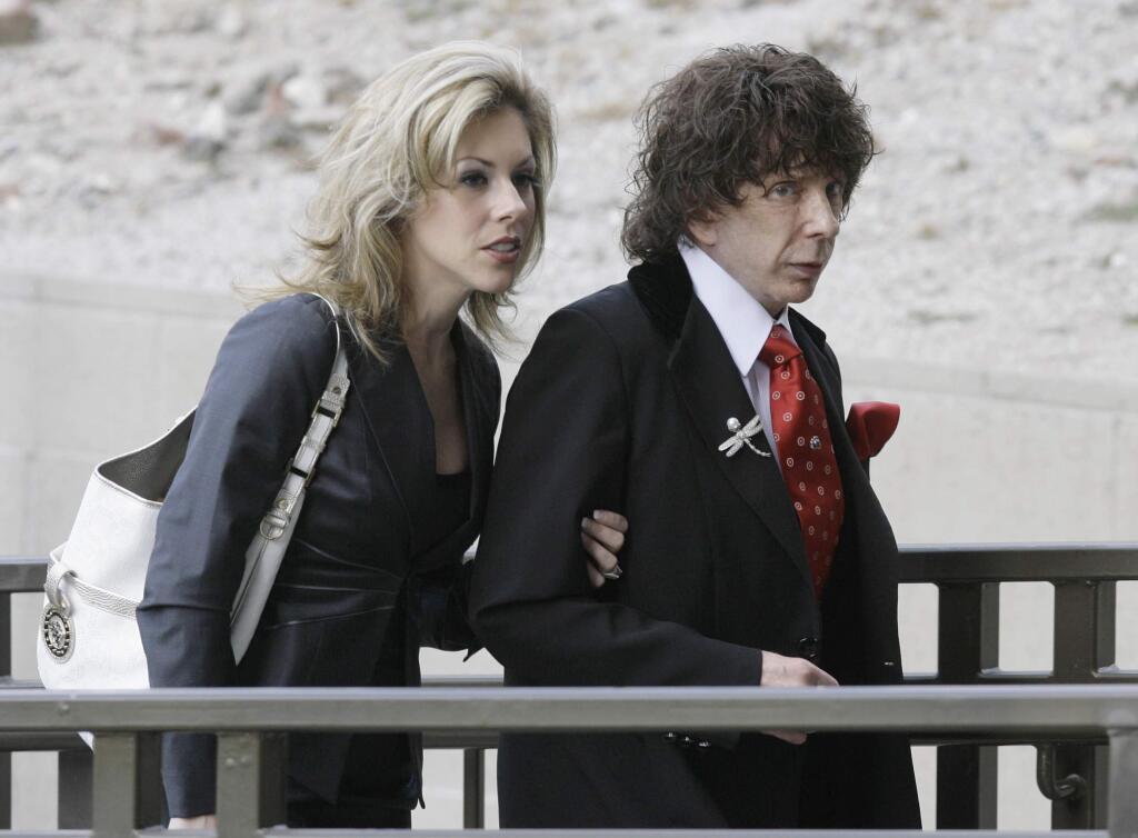 FILE - In this March 28, 2008 file photo, music producer Phil Spector and his wife Rachelle Spector, arrive at the Los Angeles County Superior Court for a discovery hearing in downtown Los Angeles. An attorney for Spector's wife Rachelle wrote in a statement issued Tuesday, April 26, 2016, that the producer's divorce filing is 'heartbreakingly bizarre' and that she has been a devoted wife who has given him the best possible care while he is imprisoned for the shooting death of actress Lana Clarkson. (AP Photo/Nick Ut, File)