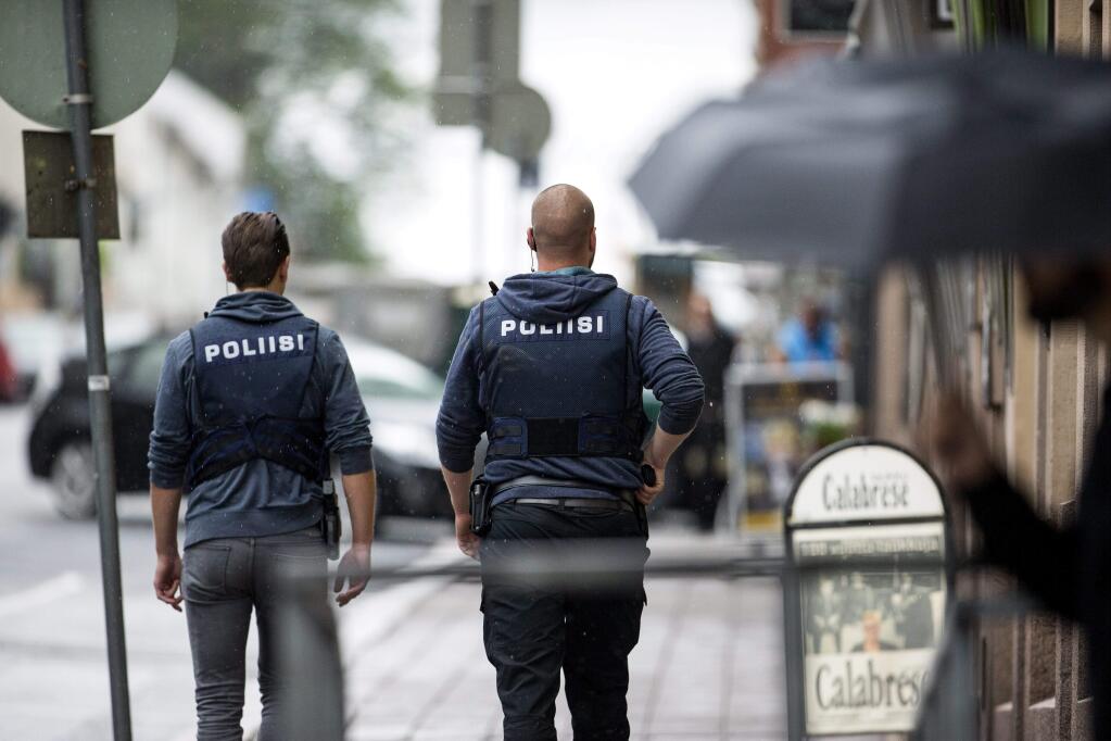 Armed police officers secure the area after several people were stabbed on the Market Square in Turku, Finland, Friday Aug. 18, 2017. A man is thought to have stabbed several people in Finland's western city of Turku before police shot him in a leg and detained him, police said, adding that authorities were looking for more potential suspects. (Roni Lehti/Lehtikuva via AP)