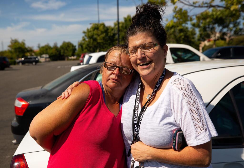 COTS homeless outreach specialist Cecily Kagy, right, embraces Emily Morris-Jarboe after visiting with Morris-Jarboe and other homeless people in front of the Target store in Rohnert Park, California, on Thursday, August 8, 2019. (Alvin Jornada / The Press Democrat)
