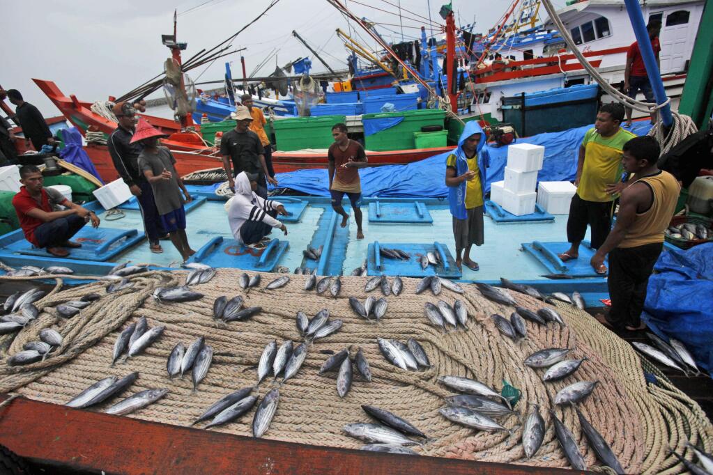 Fish vendors wait for customers at a fishing port in Banda Aceh, Aceh province, Indonesia in 2014. (AP Photo/Binsar Bakkara)