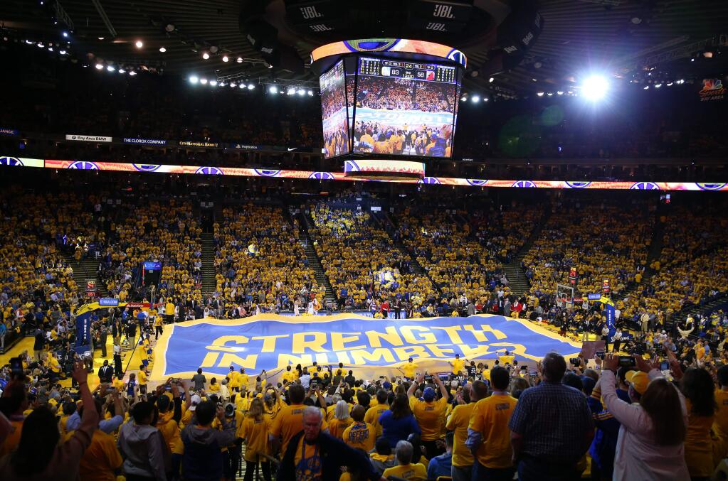 A large 'Strength In Numbers' flag is brought out during Game 2 of the first round of the NBA playoffs between the Golden State Warriors and Portland Trail Blazers in Oakland on Wednesday, April 19, 2017. (Christopher Chung / The Press Democrat)