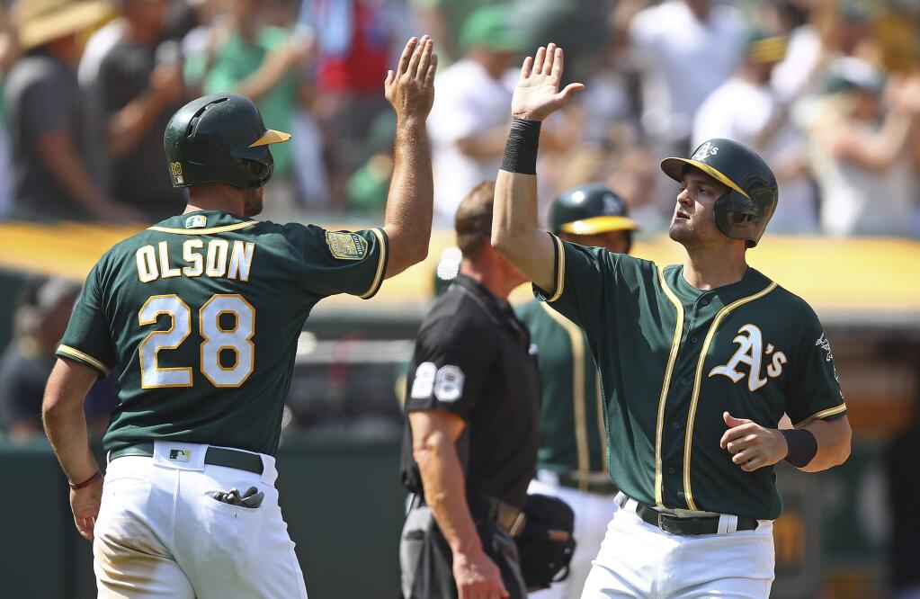 The Oakland Athletics' Matt Olson and Chad Pinder celebrate after scoring against the Houston Astros in the eighth inning Saturday, Aug. 18, 2018, in Oakland. Both scored on a double by Josh Phegley. (AP Photo/Ben Margot)