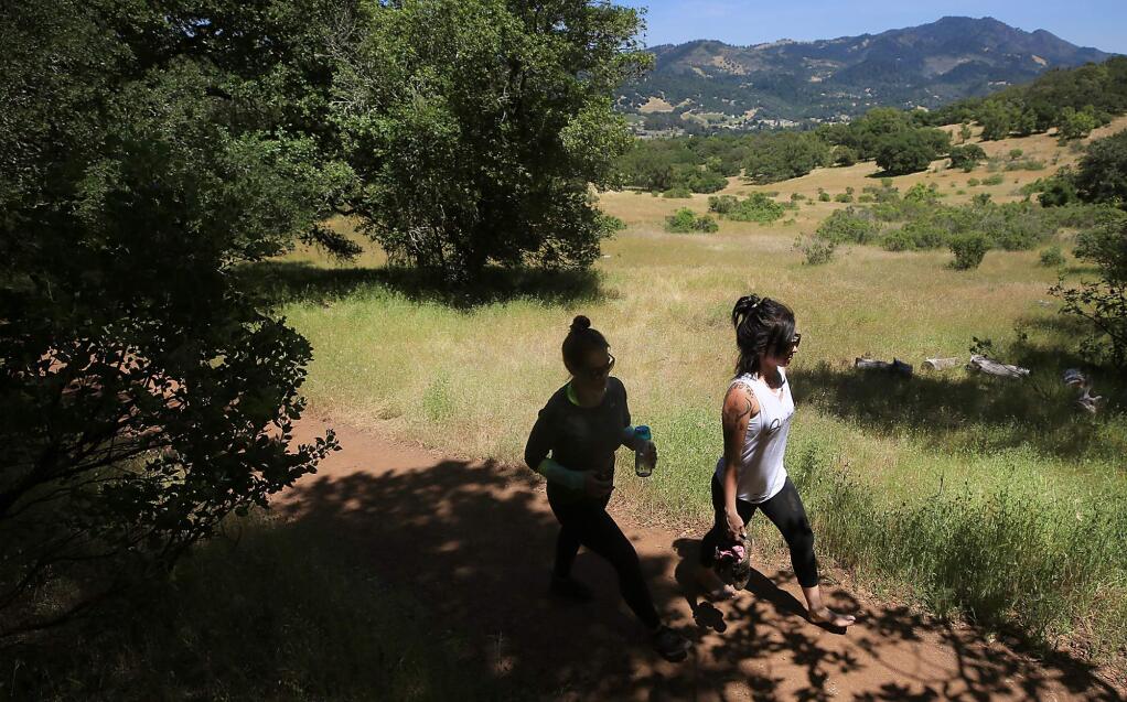 Marceila Barragan, left and Amanda Clark hike along Cobblestone Trail in Trione-Annadel State Park in Santa Rosa, Monday May 22, 2017. A program to raise money through state park license plates has failed, creating a gap in funding for the parks. In the background is Sugarloaf State Park. (Kent Porter / Press Democrat) 2017