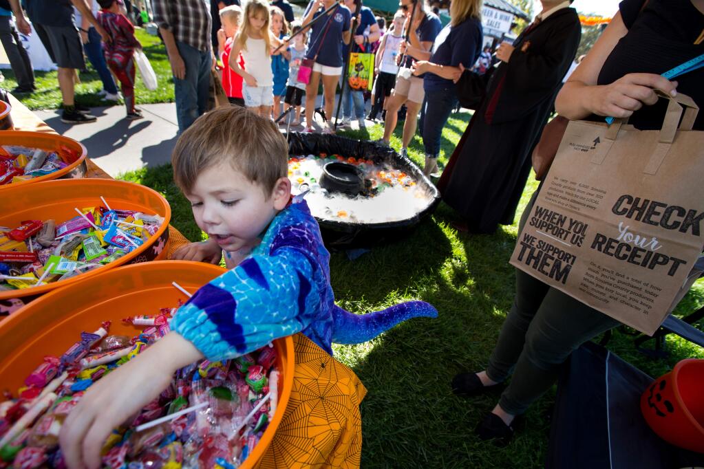Dexter King, 4, of Windsor, reaches for candy after winning a game played by children during the Harvest Festival at Windsor Town Green in Windsor, Calif., on Saturday, October 28, 2017. (Photo by Darryl Bush / For The Press Democrat)