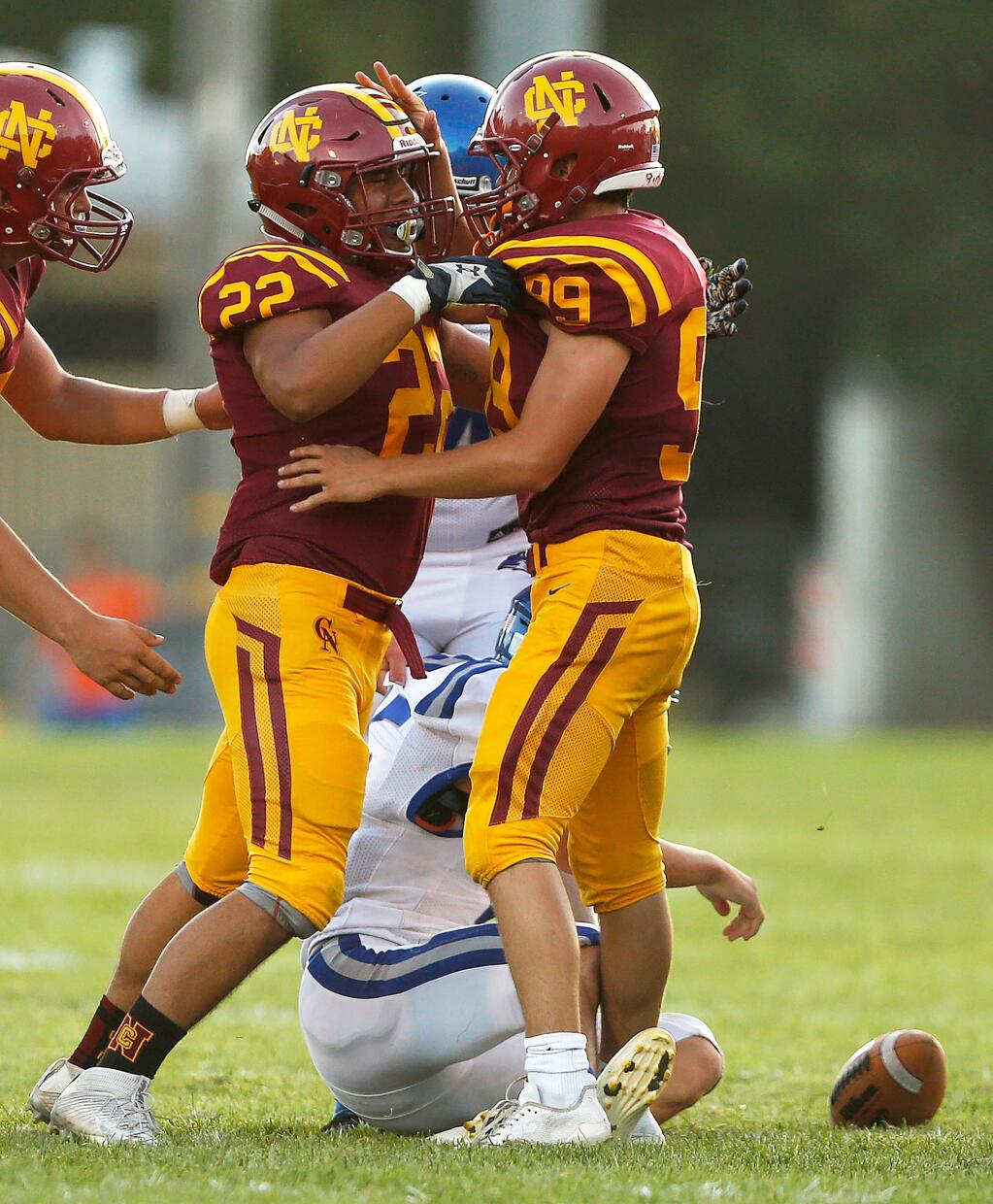 Cardinal Newman's Emylio Vega (22), left, and Bailey Ayre (99) celebrate after teaming up to sack Fortuna quarterback Daeden Taylor (15) in the backfield during the first half of a varsity football game between Fortuna and Cardinal Newman high schools at Healdsburg Recreation Park, in Healdsburg, California, on Thursday, August 22, 2019. (Alvin Jornada / The Press Democrat)
