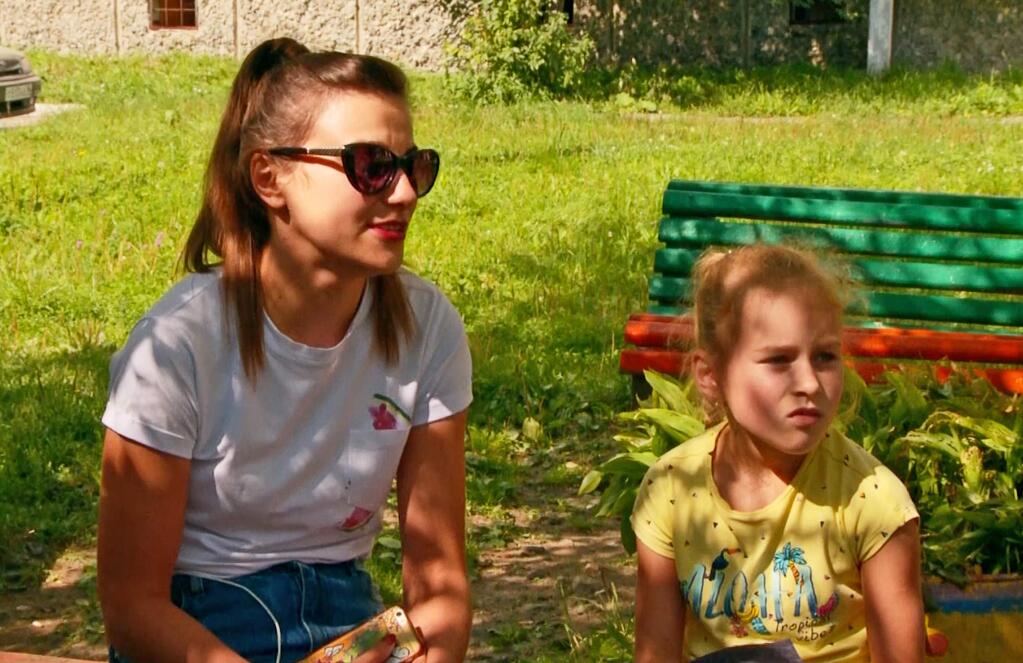 In this video grab provided by the RU-RTR Russian television, Natalia Yusupova, wife of Damir Yusupov, 41, the captain of Ural Airlines A321 and her daughter speak to journalists in Polevskoy, near Yekaterinburg, Russia, Thursday, Aug. 15, 2019. Russian Ural Airlines' A321, carrying 226 passengers and a crew of seven, collided with a flock of birds while taking off Thursday from Moscow's Zhukovsky airport, and the pilot is being hailed as a hero.(RU-RTR Russian Television via AP)