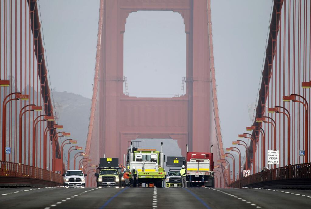 A road crew installs the movable median barrier on the Golden Gate Bridge in San Francisco, on Saturday, Jan 10, 2015. (AP Photo/San Francisco Chronicle, Paul Chinn)