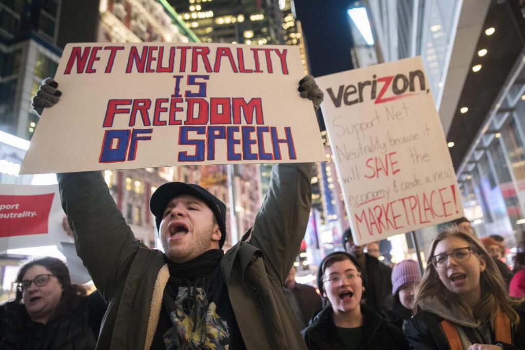 In this Thursday, Dec. 7, 2017, file photo, Demonstrators rally in support of net neutrality outside a Verizon store in New York. (AP Photo/Mary Altaffer, File)