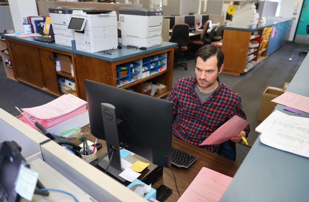 Election specialist Jason Bensley enters voter registration updates for changes that were made at the polls, at the Registrar of Voters Office, in Santa Rosa on Thursday, March 26, 2020. (Christopher Chung/ The Press Democrat)