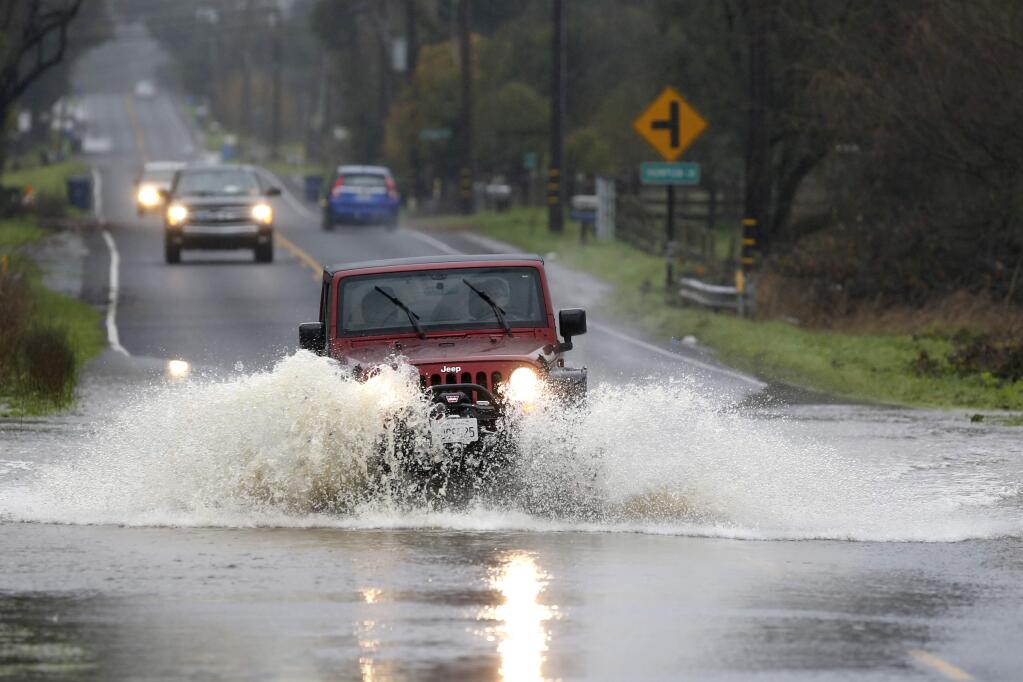 A car drives through flood water on Corona Road near Thompson Lane on Jan. 10, 2017 in Petaluma. (BETH SCHLANKER/The Press Democrat)