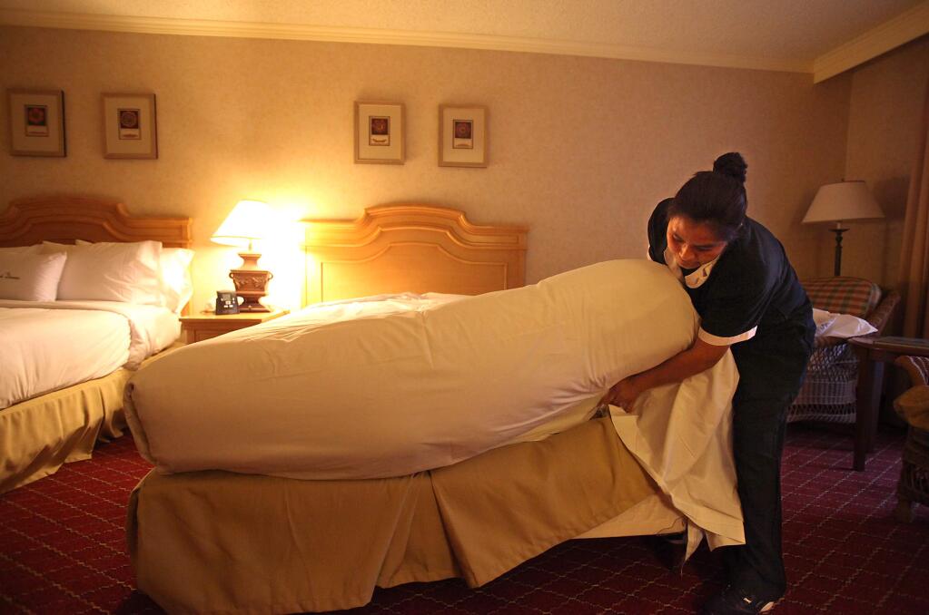 Housekeeper Minerva Cruz makes the bed in a room in the DoubleTree by Hilton Hotel Sonoma in Rohnert Park in 2011. (CHRISTOPHER CHUNG/ PD FILE)