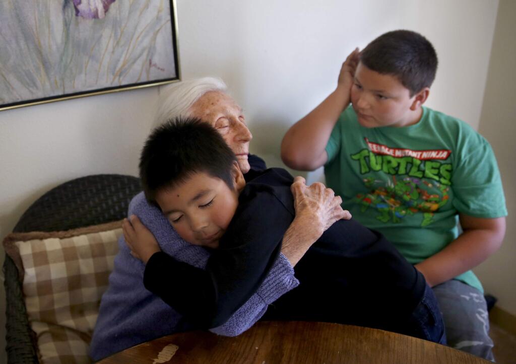 PHOTO: 1 by BETH SCHLANKER / The Press Democrat -Tomales Elementary School students Isaiah Flores, 8, and Daniel Petersen, 11, right, visit with 100-year-old Elsie Roberts at her home in Tomales.
