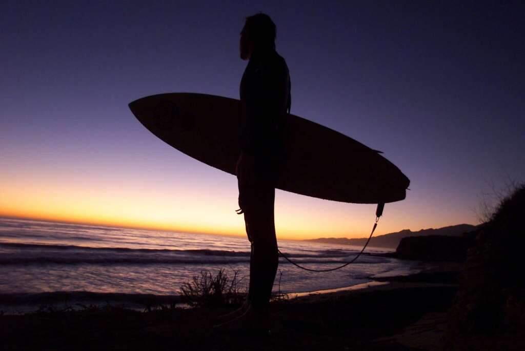 Surfer Tyler Whitmore, of Santa Ynez, Calif., looks out over Hollister Ranch's surf at sunset Wednesday, Nov. 17, 1998. Surfers park their vehicles along Highway 101 and climb down to the uncrowded Southern California beach and surf area, one of the largest stretches of beach in private hands. (Spencer Weiner/Associated Press)