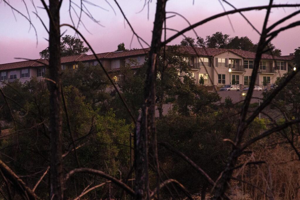 Villa Capri at Varenna is seen through the branches of burned trees that stll remain along Vintage Circle, in Santa Rosa, California, on Thursday, July 18, 2019. (Alvin Jornada / The Press Democrat)