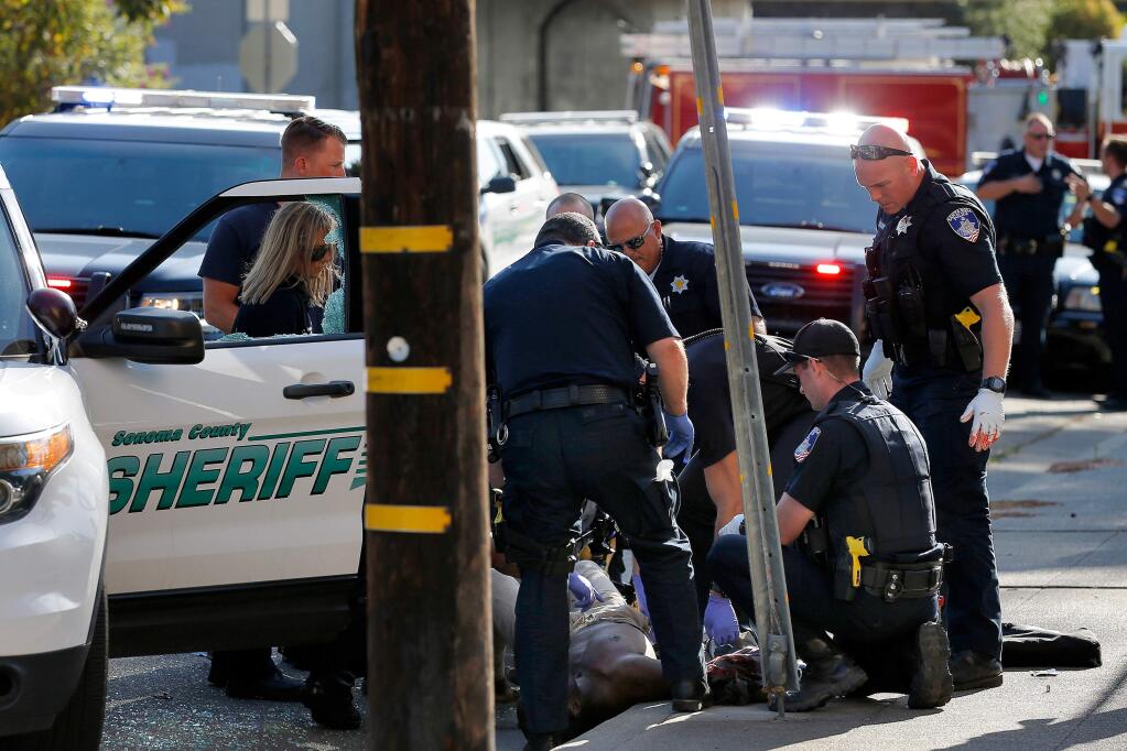 Medical personnel and law enforcement officers treat the gunshot injuries of a man after a deputy-involved shooting near the intersection of 9th and Morgan streets in Santa Rosa, California, on Thursday, Aug. 1, 2019. (ALVIN JORNADA/ PD)
