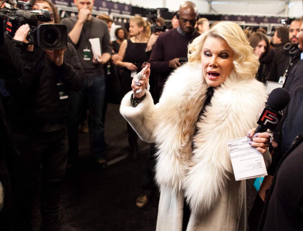 In this Feb. 14, 2012 file photo, Joan Rivers tours backstage with her camera crew for E!'s 'Fashion Police,' before the Badgley Mischka show during Fashion Week in New York. Joan Rivers died Thursday, Sept. 4, 2014. (AP Photo/John Minchillo, File)